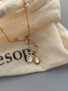 Gros plan de colliers en argent 925 avec pendentifs en nacre ovale sur un sac en tissu
