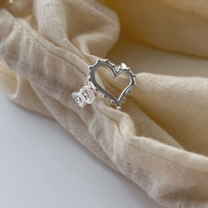 Bague cœur en argent sterling 925 avec design géométrique sur tissu beige doux