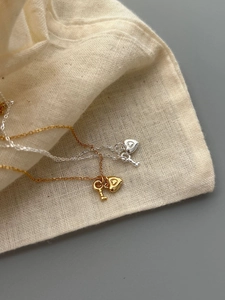 Detailed view of heart and key pendants on gold and silver 925 sterling silver necklaces