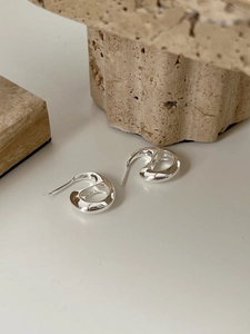Close-up of silver irregular organic geometric earrings with polished mirror finish