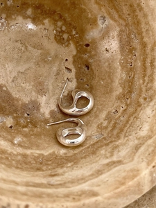 Detailed view of silver minimalist hollow earrings with a liquid metal texture design