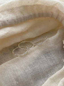 Detailed close-up of a 925 sterling silver bow knot ring set on soft linen fabric