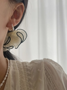 Detail of 925 sterling silver liquid metal earrings worn with elegant accessories