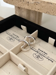 Macro detail of 925 silver hollow letter rings displayed in a luxury jewelry gift box