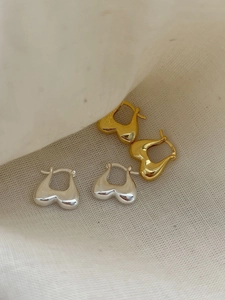 Close-up of S925 hallmark on heart-shaped sterling silver earrings with mirror finish