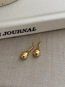 Close-up of elegant gold water drop stud earrings with high-polish mirror finish