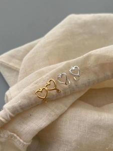 Detail of minimalist 925 silver hollow heart earrings in gold and silver finishes