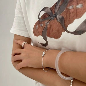Minimalist 925 silver croissant snake bone bracelet and petal ring worn by a model