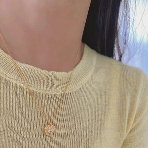 Elegant gold heart pendant necklace with radiant texture and zircon on a fine chain