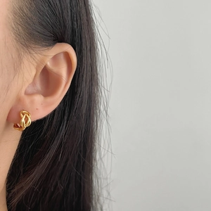 Boucles d'oreilles torsadées en argent 925 doré portées par un mannequin femme