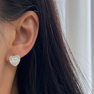 S925 sterling silver heart earrings with radiant texture and center zircon on model