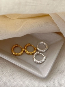 Detailed close-up of 925 sterling silver hoop earrings with hammered texture finish