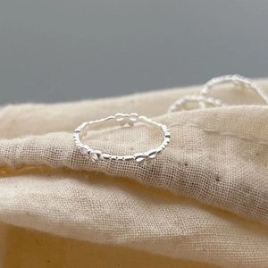 Minimalist 925 sterling silver bow open ring for women on a natural linen fabric bag