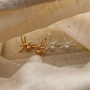 Minimalist knot-shaped 925 silver earrings in gold and silver finish on fabric pouch