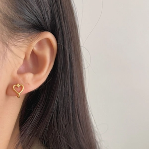 Minimalist 925 sterling silver hollow heart hoop earrings in gold finish worn on ear