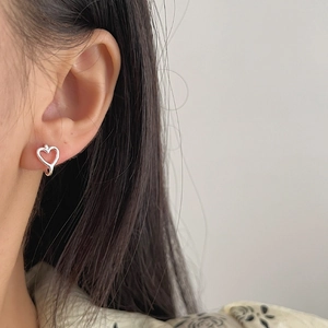 Elegant 925 sterling silver hollow heart earrings worn by a model in a minimalist style
