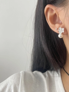 Detail of 925 sterling silver flower earrings with white pearl on a female model