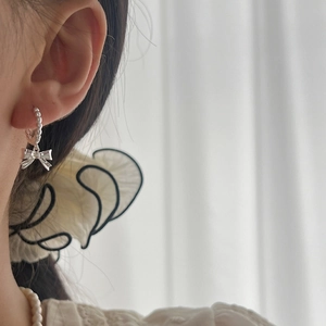 Elegant S925 sterling silver bow earrings with beaded hoops shown on a model