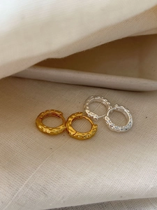 Detailed macro view of S925 sterling silver earrings with unique hammered texture finish