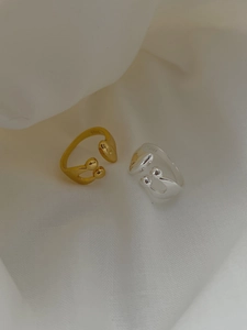 Detail showing S925 hallmark on gold and silver asymmetrical water drop open rings