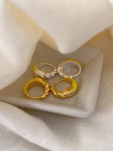 Detailed close-up of S925 sterling silver enamel twist hoop earrings on stone tray