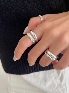 Detailed view of stacked S925 sterling silver rings showing various textures and styles