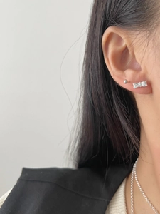 Gros plan sur boucle d'oreille nœud en argent S925 avec pierres et puce ronde