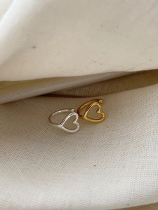 Macro shot of minimalist hollow heart ear clips in polished gold and silver finishes