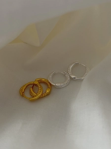 Detail of twisted rope and bead texture on gold and silver 925 silver hoop earrings