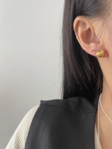 Close-up of 925 sterling silver golden heart earrings featuring a vertical ribbed texture