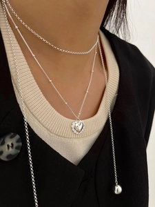 Détail d'un collier à plusieurs rangs argenté avec pendentif coeur sur mannequin