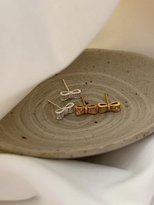 Vue détaillée des boucles d'oreilles nœud en argent S925 avec zircons en or et argent
