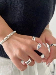 Detailed view of stacked 925 sterling silver rings with twisted rope and teardrop designs