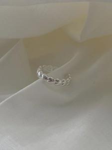 Detail shot of adjustable S925 silver ring with woven wheat pattern on silk