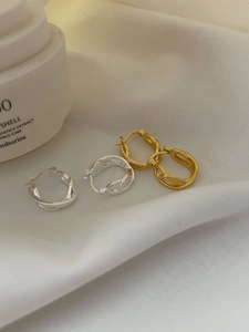 Detail showing the S925 hallmark on intertwined silver and gold hoop earrings