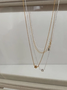 Détail de colliers avec pendentifs fleurs en argent 925 aux finitions or et argent