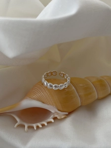 Detail of adjustable S925 sterling silver ring with leaf patterns on a seashell