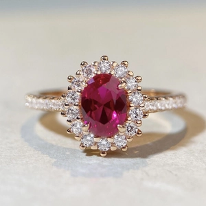 Vue macro d'une bague halo rubis ovale avec petits diamants sur or rose