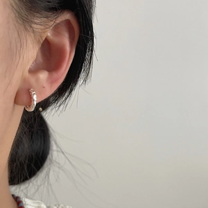 Minimalist 925 sterling silver hoop earrings with irregular hammered texture on model