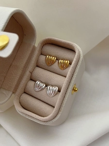 Detail of 925 sterling silver heart earrings in gold and silver with vertical texture