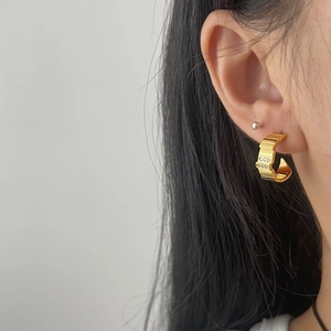 Classic gold C-shaped hoop earrings with striped texture and triple row of clear zircons