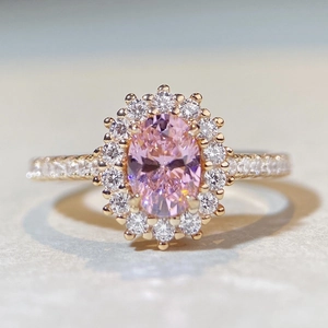 Vue macro d'une bague en or rose avec gemme rose ovale et pavé de diamants