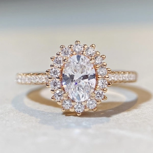 Détail d'une bague avec diamant rose ovale, halo et pavage en finition or rose