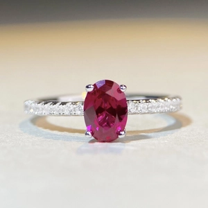 Macro view of oval ruby ring with small diamonds on s925 sterling silver band