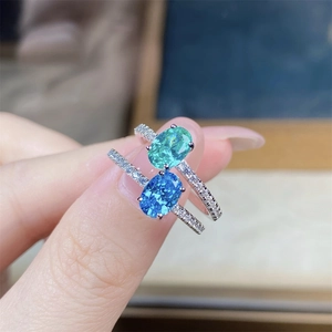 Macro view of S925 silver rings with oval aquamarine and green gemstones in pave setting
