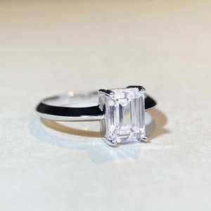 Macro shot of 2ct emerald cut moissanite ring with classic four-prong 925 silver setting