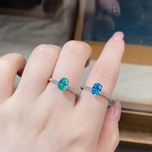 Detailed macro view of S925 silver rings featuring oval green and blue gemstones with pavé diamonds