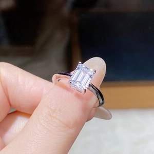 Macro view of 2ct emerald cut moissanite ring with classic four-prong silver setting