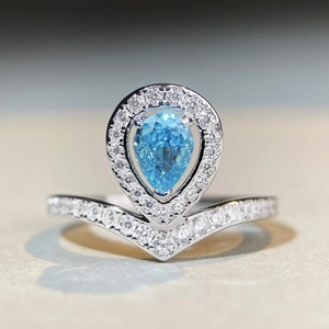 Macro shot of pear shaped aquamarine ring with V-shaped pavé band detail