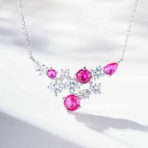 Macro shot of silver necklace featuring rose red pear-cut and round white zircon cluster